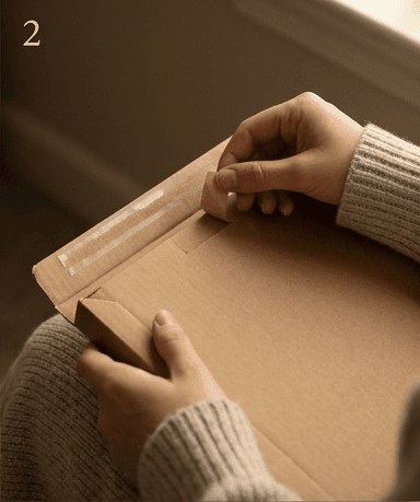 Hands pulling open the tab of the plain mailer